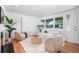 Bright living room featuring hardwood floors, a large window, comfortable furniture, and stylish decor at 7121 E Arkansas Ave, Denver, CO 80224