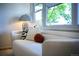 Close up of a couch with decorative pillows, unique lamp, and window with a view of mature landscaping at 7121 E Arkansas Ave, Denver, CO 80224