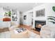 Bright living room with a fireplace, comfortable seating, built-in shelving and hardwood floors at 7121 E Arkansas Ave, Denver, CO 80224