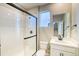 Bathroom featuring a modern shower with glass door, sleek vanity, and stylish fixtures at 8633 Middle Fork St, Littleton, CO 80125