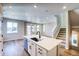 Bright open-concept kitchen with an island featuring a sink, extending into a spacious living area at 8633 Middle Fork St, Littleton, CO 80125