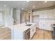Contemporary kitchen featuring white cabinets, a large island, stainless steel appliances, and wood-look flooring at 8633 Middle Fork St, Littleton, CO 80125