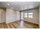 Spacious living room with wood-look floors, neutral walls, recessed lighting, and large windows at 8633 Middle Fork St, Littleton, CO 80125