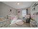 Adorable Bedroom with a white crib, plush rug, and cozy armchair at 20898 E Hamilton Ave, Aurora, CO 80013