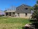 Back exterior view of the house, patio with chairs, swing and a grassy yard at 4609 S Kalispell Way, Aurora, CO 80015