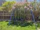 Backyard with lush green grass, a blue swing set, and partial view of a wooden fence at 4609 S Kalispell Way, Aurora, CO 80015