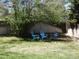 Landscaped backyard featuring mature tree coverage and a charming seating area at 4609 S Kalispell Way, Aurora, CO 80015