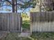 Backyard with grass, mature trees and partial view of a public field behind the wooden fence at 4609 S Kalispell Way, Aurora, CO 80015
