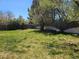Backyard with lush green grass, mature trees, and a wooden fence around the property at 4609 S Kalispell Way, Aurora, CO 80015