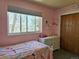 Bright bedroom with pink walls, dresser, window, and closet at 4609 S Kalispell Way, Aurora, CO 80015
