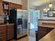 Kitchen area with stainless steel refrigerator, wood cabinets, and a view to the backyard for an open concept feel at 4609 S Kalispell Way, Aurora, CO 80015