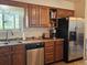 Kitchen featuring stainless steel appliances, wood cabinets, and a window for a bright and efficient cooking experience at 4609 S Kalispell Way, Aurora, CO 80015