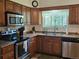 Efficient kitchen with stainless steel appliances, wood cabinets, and a window providing natural light for a functional space at 4609 S Kalispell Way, Aurora, CO 80015