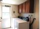 Functional laundry room featuring overhead cabinets and appliances, leading to exterior access at 4609 S Kalispell Way, Aurora, CO 80015
