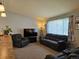 Comfortable living room showcasing plush seating, neutral walls, and a window with natural light for a cozy atmosphere at 4609 S Kalispell Way, Aurora, CO 80015