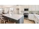 Open kitchen with a large island, stainless steel appliances, and a stylish backsplash at 10880 E Hinsdale Cir, Centennial, CO 80112
