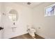 Clean and modern powder room featuring a sleek sink, round mirror, and wood-look flooring at 10880 E Hinsdale Cir, Centennial, CO 80112
