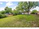 Expansive backyard featuring lush green grass, mature trees, and a wooden fence at 7563 Lamar Ct, Arvada, CO 80003