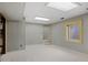 Open basement area featuring gray carpet, neutral paint, stairs and a window at 7563 Lamar Ct, Arvada, CO 80003