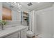 Bathroom with white fixtures, walk in shower, decorative shelving and large mirror at 7563 Lamar Ct, Arvada, CO 80003