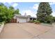 Charming home featuring a two-car garage and a well-maintained front yard with blooming flowers at 7563 Lamar Ct, Arvada, CO 80003