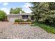 Charming home with a two-car garage and a beautifully landscaped front yard with rock and blooming flowers at 7563 Lamar Ct, Arvada, CO 80003