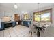 Well-lit kitchen and dining area with white tile floors, blue lower cabinets, and a bright, airy feel at 7563 Lamar Ct, Arvada, CO 80003