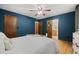 Blue bedroom with neutral furnishings, hardwood flooring, and access to adjacent rooms at 7563 Lamar Ct, Arvada, CO 80003