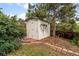 Backyard shed with a ladder and surrounded by lush greenery and trees at 7563 Lamar Ct, Arvada, CO 80003