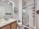Bright bathroom featuring a glass-enclosed shower, framed art, and stylish vanity lighting at 11811 Lewiston St, Commerce City, CO 80022