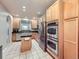 Open kitchen featuring stainless steel appliances, oak cabinets, and an island at 11811 Lewiston St, Commerce City, CO 80022