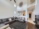 Bright living room with high ceilings, a fireplace, and a large sectional sofa at 11811 Lewiston St, Commerce City, CO 80022