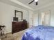 Bright main bedroom with a tray ceiling, carpet and a dark wood dresser at 11811 Lewiston St, Commerce City, CO 80022