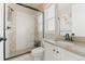 Bathroom featuring glass shower, white vanity with black hardware, and neutral tones with accent tiles at 19475 W 94Th Ave, Arvada, CO 80007