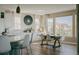 Bright dining area featuring a large table, modern chairs, and views of the front yard at 19475 W 94Th Ave, Arvada, CO 80007