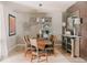 This dining room features a wooden table with seating for eight beneath a modern chandelier at 19475 W 94Th Ave, Arvada, CO 80007