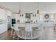 Stylish kitchen featuring white cabinets, a center island with barstools, and stainless steel appliances at 19475 W 94Th Ave, Arvada, CO 80007