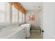 Well-lit laundry room with white cabinets, sink, washer, and dryer at 19475 W 94Th Ave, Arvada, CO 80007