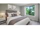 Comfortable bedroom with a plush bed, neutral decor, and a bright window view at 2076 S Holly St # 1, Denver, CO 80222
