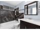 Bathroom featuring a shower-over-tub, brown tile surround, white fixtures, and a dark wood vanity at 3742 S Granby Way, Aurora, CO 80014