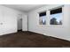 Bedroom with neutral walls, dark brown carpet, a large window and a closet with white doors at 3742 S Granby Way, Aurora, CO 80014