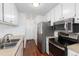 Efficient kitchen featuring stainless steel appliances, white cabinets, and wood flooring at 3742 S Granby Way, Aurora, CO 80014