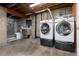 Laundry room with gray concrete flooring, stacked washer and dryer, and an adjacent bathroom at 3742 S Granby Way, Aurora, CO 80014