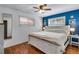 Charming bedroom featuring hardwood floors, stylish ceiling fan, and an eye-catching accent wall at 5620 E Cornell Ave, Denver, CO 80222