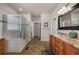 Bathroom with a glass enclosed shower, custom vanity, and tile floors at 15616 Soo Line Way, Monument, CO 80132