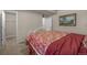 Bedroom with red floral bedding, adjacent closet and doorway, and a framed painting on the wall at 15616 Soo Line Way, Monument, CO 80132