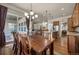 Spacious dining room with stylish chandelier, wooden table, and access to the kitchen and outdoor space at 15616 Soo Line Way, Monument, CO 80132