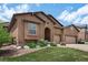 Inviting stucco home featuring stone accents, arched entryway, three-car garage, and landscaped front yard at 15616 Soo Line Way, Monument, CO 80132