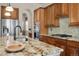 Bright kitchen features stainless steel appliances, granite countertops, and custom wood cabinets at 15616 Soo Line Way, Monument, CO 80132