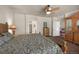 Well-lit main bedroom with elegant wooden furnishings, ceiling fan, and ample natural light at 15616 Soo Line Way, Monument, CO 80132